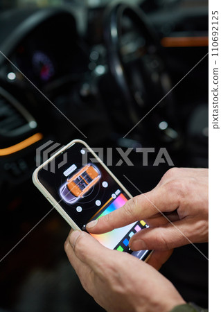 Man in car adjusting smart home device via smartphone Man in car adjusting smart home device via smartphone 110692125