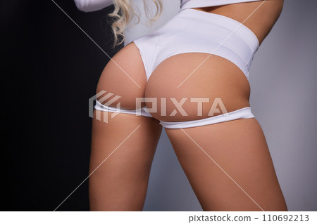 Slender narrow waist. Close up strong abdominal muscles of a young sporty woman. 110692213