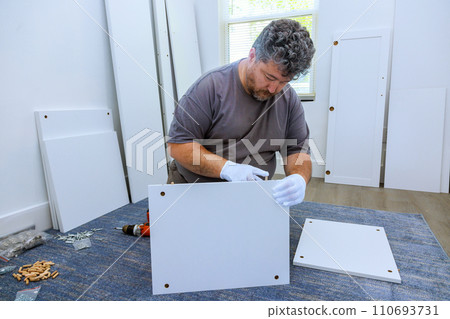 Using screwdriver to assemble furniture closet cabinet Using screwdriver to assemble furniture closet cabinet 110693731