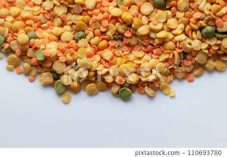 A background of dry yellow and green peas in close-up on a white background with a place for text, top view. 110693780