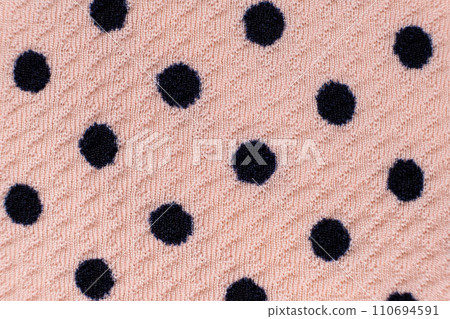 Blue circles patterns on synthetic pink polyester fabric close-up. 110694591