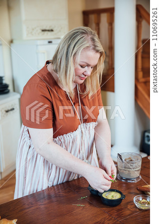 Woman cook at home in kitchen preparing delicious food Woman cook at home in kitchen preparing delicious food 110695261