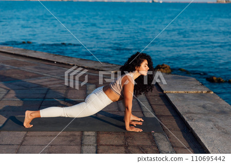 Caucasian woman practicing yoga at seashore 110695442