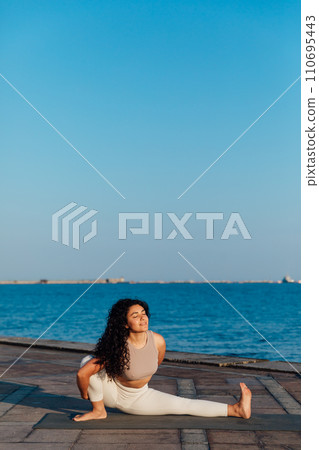 Caucasian woman practicing yoga at seashore Caucasian woman practicing yoga at seashore 110695443