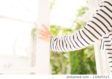 從明亮的室內打開白色框窗的人的肖像 110695523