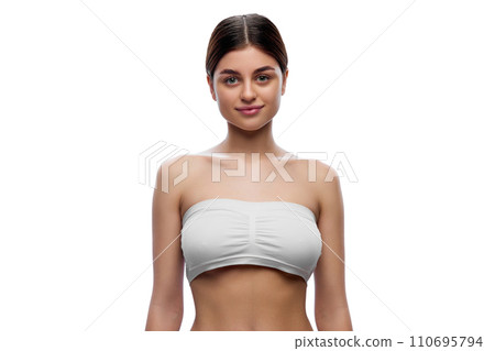 Half-length portrait of young attractive woman in white underwear posing looking at camera against white studio background. Half-length portrait of young attractive woman in white underwear posing looking at camera against white studio background. 110695794