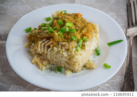 cooked bulgur with meat sauce and vegetables in a plate 110695911