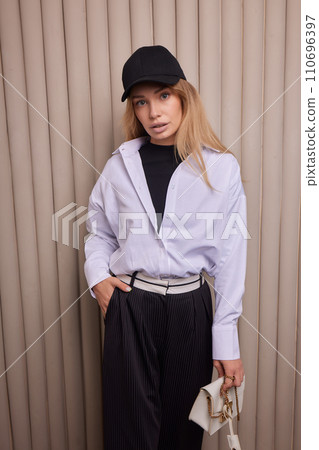 High fashion photo of a beautiful elegant young woman in a pretty beige suit 110696397