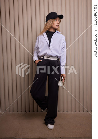 High fashion photo of a beautiful elegant young woman in a pretty beige suit 110696401