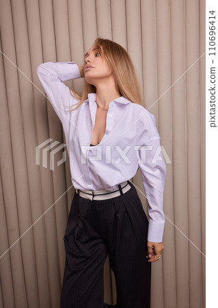 High fashion photo of a beautiful elegant young woman in a pretty beige suit High fashion photo of a beautiful elegant young woman in a pretty beige suit 110696414