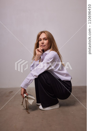 High fashion photo of a beautiful elegant young woman in a pretty beige suit High fashion photo of a beautiful elegant young woman in a pretty beige suit 110696450