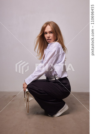 High fashion photo of a beautiful elegant young woman in a pretty beige suit High fashion photo of a beautiful elegant young woman in a pretty beige suit 110696455