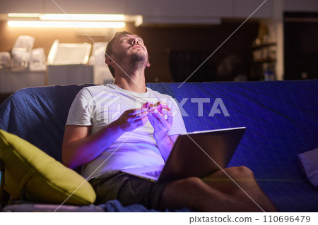 a young man, wearing latex gloves, preparing a falafel sandwich in a pita bread, with chopped tomato and onion a young man, wearing latex gloves, preparing a falafel sandwich in a pita bread, with chopped tomato and onion 110696479