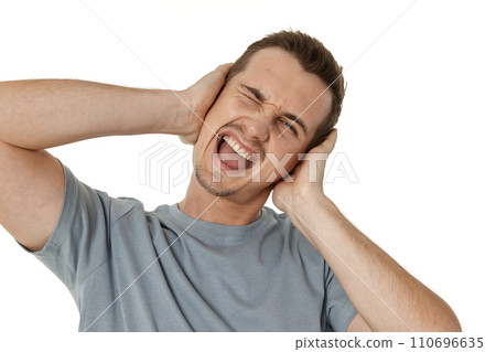 caucasian man in t-shirt covers ears with hands on white background caucasian man in t-shirt covers ears with hands on white background 110696635
