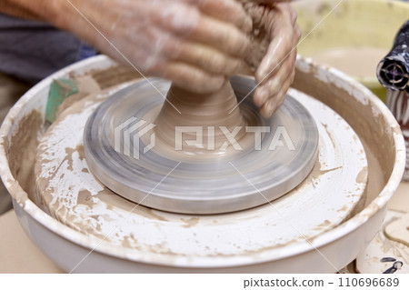 male hands making ceramic cup on pottery wheel, Close-up 110696689