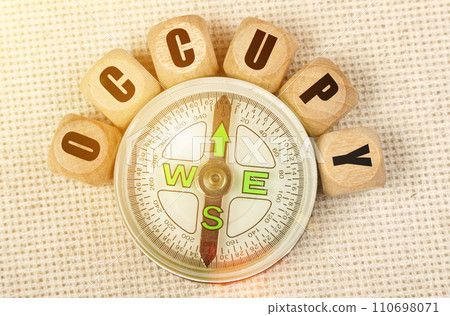 On the table is a compass and cubes with the inscription - OCCUPY On the table is a compass and cubes with the inscription - OCCUPY 110698071
