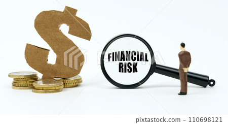 On a white surface, a dollar symbol, a human figure and a magnifying glass with the inscription - financial risk On a white surface, a dollar symbol, a human figure and a magnifying glass with the inscription - financial risk 110698121