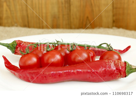 cherry tomatoes and pods of chili peppers cherry tomatoes and pods of chili peppers 110698317