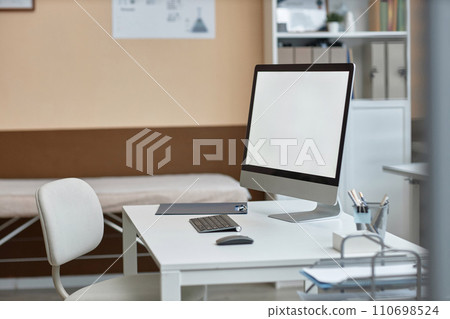 Side view of working computer monitor with blank screen on white office table in private clinic Side view of working computer monitor with blank screen on white office table in private clinic 110698524