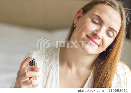 Serene Woman Enjoying Scent of Perfume Serene Woman Enjoying Scent of Perfume 110698681