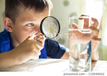 Boy Investigating Water with Magnifying Glass Boy Investigating Water with Magnifying Glass 110698682