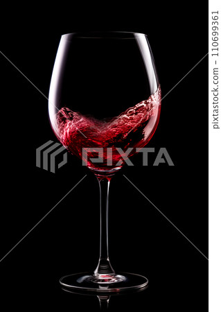 A glass with red wine is isolated on black background. Rose wine splashing in glassware. A glass with red wine is isolated on black background. Rose wine splashing in glassware. 110699361
