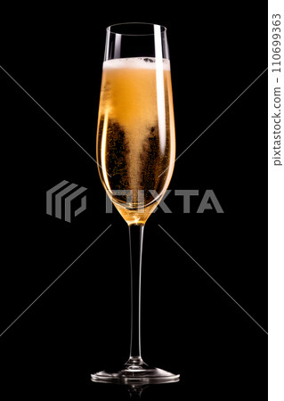 A crystal-clear flute glass of champagne isolated on black background A crystal-clear flute glass of champagne isolated on black background 110699363