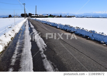 Ruts on the snowy road 110699672