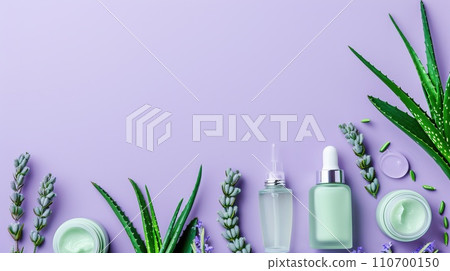 Arrangement of aloe skincare products, delicate containers set with aloe vera leaves on a pastel lavender background Arrangement of aloe skincare products, delicate containers set with aloe vera leaves on a pastel lavender background 110700150