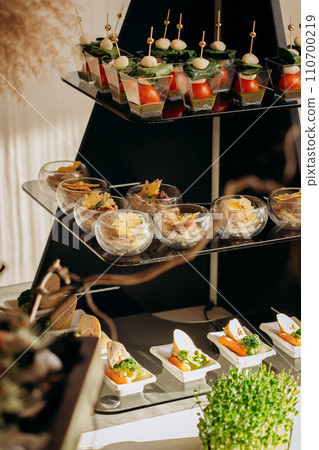 Assortment of delicious snacks on the open buffet festive table in restaurant. Catering plate Assortment of delicious snacks on the open buffet festive table in restaurant. Catering plate 110700219
