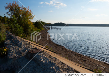 lake with waves on the background of a sandy beach and forest 110700625