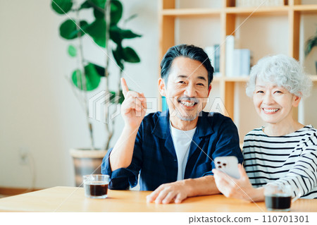 A senior couple looking at their smartphones together. A senior couple looking at their smartphones together. 110701301
