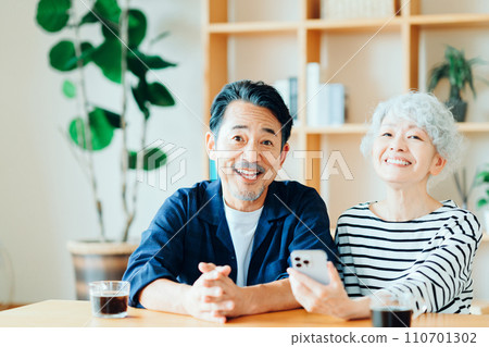 A senior couple looking at their smartphones together. A senior couple looking at their smartphones together. 110701302
