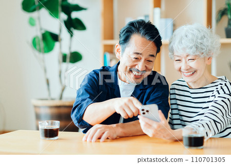 A senior couple looking at their smartphones together. A senior couple looking at their smartphones together. 110701305