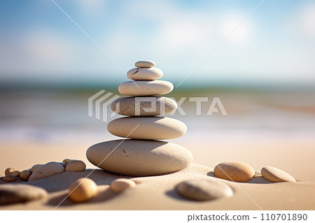 Zen stones stack on sand waves in a minimalist setting for balance and harmony 110701890