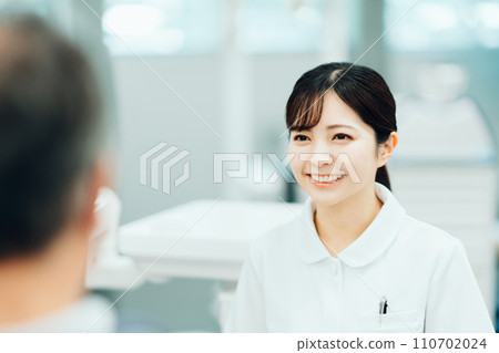 A female medical worker giving an explanation to a patient. A female medical worker giving an explanation to a patient. 110702024