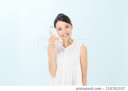 A woman drinking water of a plastic bottle A woman drinking water of a plastic bottle 110702337