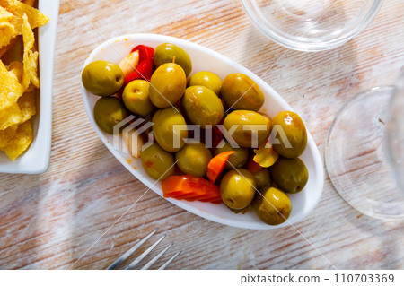 Light snack - oval bowl with pickled vegetables and green olives 110703369