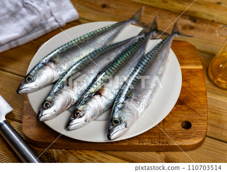 Whole mackerel carcasses are on wooden background 110703514