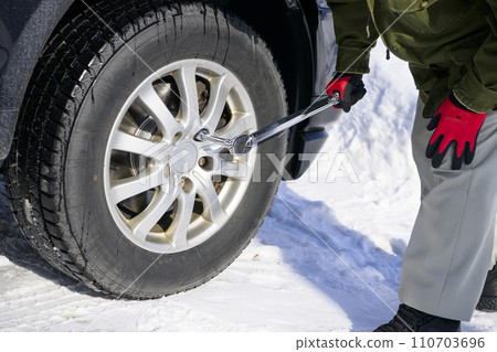 A man tightens a tire nut with a torque wrench 110703696