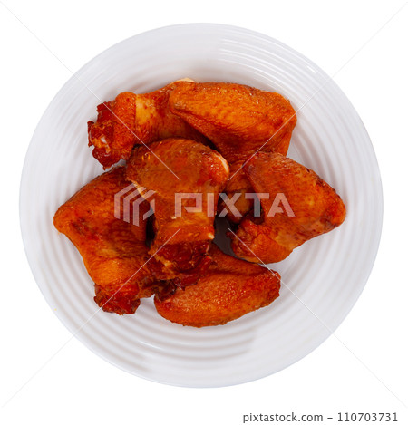 Appetizing smoked chicken wings dished up in a plate on laid restaurant table Appetizing smoked chicken wings dished up in a plate on laid restaurant table 110703731