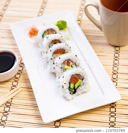 Set of uramaki rolls with salmon, avoado and cucumber closeup Set of uramaki rolls with salmon, avoado and cucumber closeup 110703769