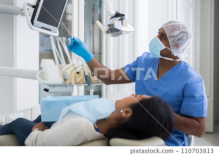 Dentist discussing treatment procedures with female patient Dentist discussing treatment procedures with female patient 110703813