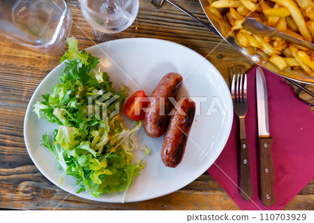 Sausages served with potatoes and salad Sausages served with potatoes and salad 110703929