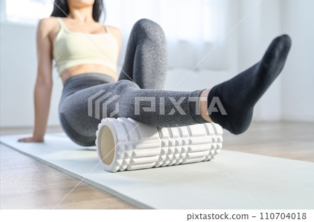 一位女士使用泡沫軸放鬆膝蓋後部 110704018