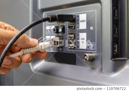 Man connects internet cable to the TV. 110706722