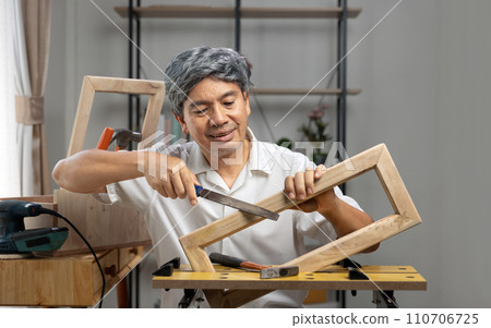 Woodworking hobby after Retirement. Senior man made a parts of woodwork  at home. 110706725