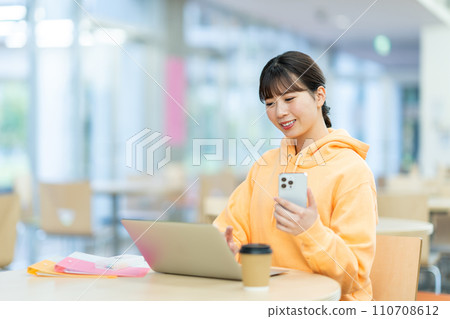 A female university student studying in the lounge. Photography cooperation: Ariake College of Education and Arts 110708612