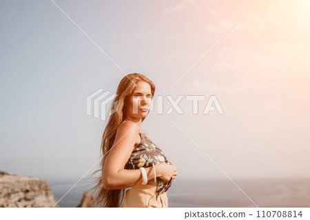 Woman travel sea. Happy tourist taking picture outdoors for memories. Woman traveler looks at the edge of the cliff on the sea bay of mountains, sharing travel adventure journey Woman travel sea. Happy tourist taking picture outdoors for memories. Woman traveler looks at the edge of the cliff on the sea bay of mountains, sharing travel adventure journey 110708814