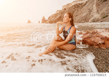 Woman summer travel sea. Happy tourist in blue bikini enjoy taking picture outdoors for memories. Woman traveler posing on the beach surrounded by volcanic mountains, sharing travel adventure journey Woman summer travel sea. Happy tourist in blue bikini enjoy taking picture outdoors for memories. Woman traveler posing on the beach surrounded by volcanic mountains, sharing travel adventure journey 110708815
